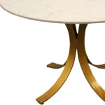 Elegant round marble dining table with ivory marble top and brass pedestal base in a modern dining room