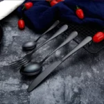 Elegant gold flatware set with fork, knife, and spoon on a white tablecloth