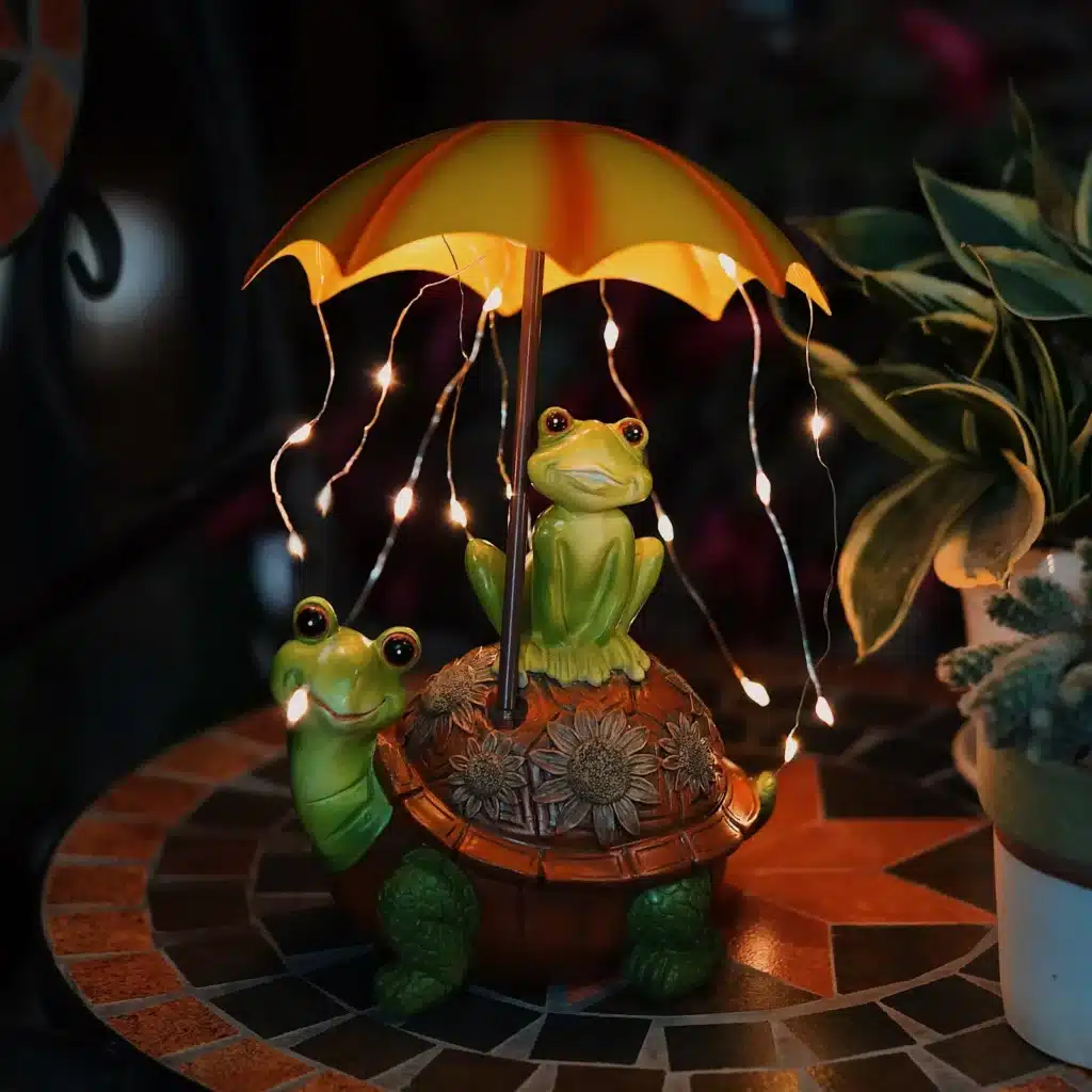 Solar frog garden statue glowing at night in a flower bed
