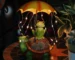 Solar frog garden statue glowing at night in a flower bed