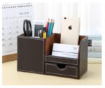 Leather PU storage box on a wooden shelf among books and decorative items.