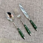 Elegant stainless steel cutlery set with fork, knife, and spoon on a wooden table