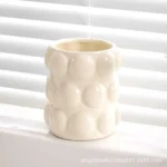Luxury electroplated mug used as a bathroom accessory, holding a toothbrush and a comb.