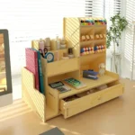 Student desktop pen holder with compartments for markers, scissors, and sticky notes, on a study table.
