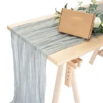 Rustic cheesecloth table runner on wooden table with boho decor