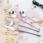 Matte gold flatware set with antique finish arranged on a wooden table