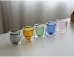 Clear double wall insulated glass mug with espresso coffee on wooden table