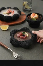 Volcanic stone sushi plate with fresh sushi rolls and wasabi on a dark textured surface