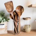 Wooden cooking utensils set with spatula, soup ladle, and rice scoop on a kitchen counter