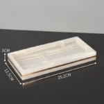 Close-up of golden pump on marble soap dispenser.