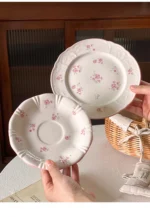 Pink cherry blossom mug with saucer on a dining table