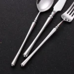 Matte gold flatware set with antique finish arranged on a wooden table
