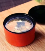 Japanese style ramen bowl set with melamine bowls, spoons, and noodle cups on a table
