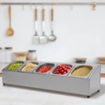 Stainless steel spice rack with 5 pans and lids on kitchen countertop