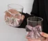 Cute pink bow tie glass cup filled with pink juice on a table