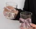 Cute pink bow tie glass cup filled with pink juice on a table