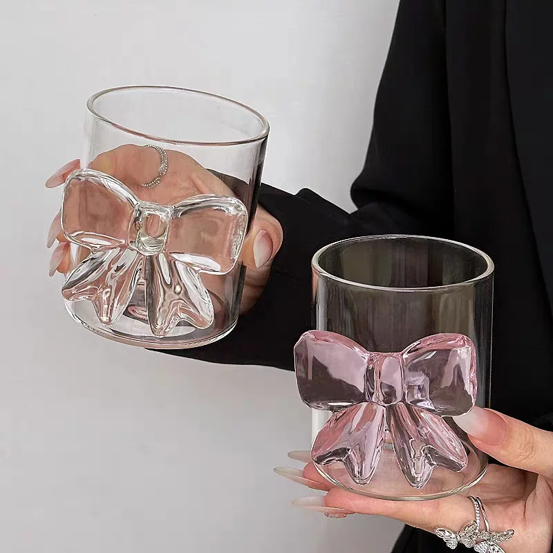 Cute pink bow tie glass cup filled with pink juice on a table