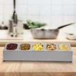 Stainless steel spice rack with 5 pans and lids on kitchen countertop
