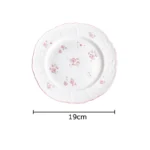 Pink cherry blossom mug with saucer on a dining table
