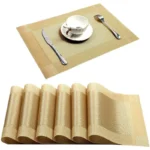 Gold weave placemats on a dining table with plates and cutlery