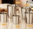 Stainless steel measuring cup with inner scale markings on a kitchen counter