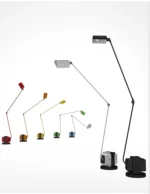 Black floor lamp in an office, providing task lighting over a desk with a laptop.