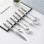 Stainless steel flatware set with ceramic pearl handles on wooden table