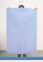 Non slip bath mat with suction cups in a white bathroom