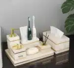 Soap dish with gold rim, angled on marble surface.