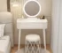 Modern makeup vanity with mirror, storage drawers, and matching stool in a bright bedroom