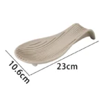 Silicone spoon rest holding a wooden spoon on a kitchen counter