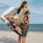 Custom photo beach towel with a vibrant family photo, lying on the sand near the ocean
