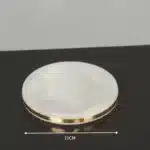 Soap dish with gold edges, empty, on marble counter.