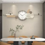 Contemporary wall clock with white round face and black numerals on a beige living room wall.