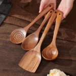 Goldoma wooden cooking utensils set with teak wood spoons, spatula, and scraper on a kitchen counter