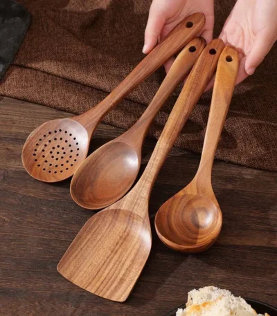Goldoma wooden cooking utensils set with teak wood spoons, spatula, and scraper on a kitchen counter