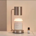 Close-up of the metal wax burner top with a melting wax pool and fragrance light, dimmable setting.