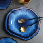 Handcrafted deep blue irregular ceramic plates on a rustic wooden table