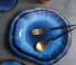 Handcrafted deep blue irregular ceramic plates on a rustic wooden table
