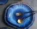 Handcrafted deep blue irregular ceramic plates on a rustic wooden table