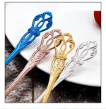 Gold flatware set with spoon, fork, and steak knife on a white tablecloth