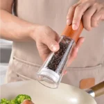 Manual pepper grinder with acrylic body and ceramic core on kitchen counter