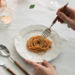 Elegant stainless steel dinnerware set with wooden handles on a rustic table