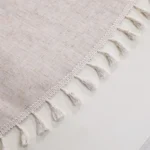 Round linen tablecloth with tassels on a dining table