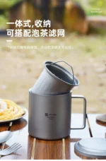 Double wall titanium mug with lid and tea strainer on a wooden table