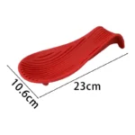 Silicone spoon rest holding a wooden spoon on a kitchen counter