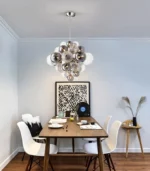 Smoky gray chandelier with glass bubbles hanging over a modern dining table