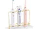 White resin electric toothbrush holder with 3 slots on a marble bathroom countertop.