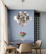 Smoky gray chandelier with glass bubbles hanging over a modern dining table