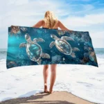 Sea turtle beach towel with vibrant underwater pattern on a sandy beach